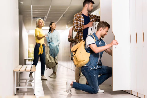 Jóvenes estudiantes pasar tiempo juntos en el pasillo de la universidad - foto de stock