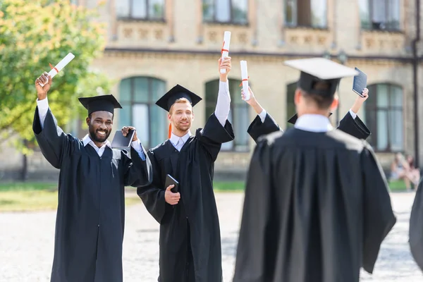 Giovani studenti laureati trascorrere del tempo in giardino universitario — Foto stock