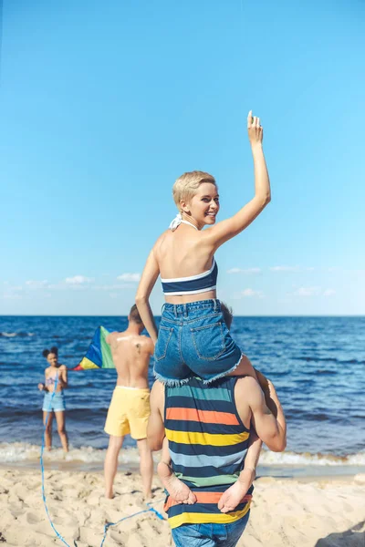 Selective focus of interracial group of friends spending time on sandy beach — Stock Photo