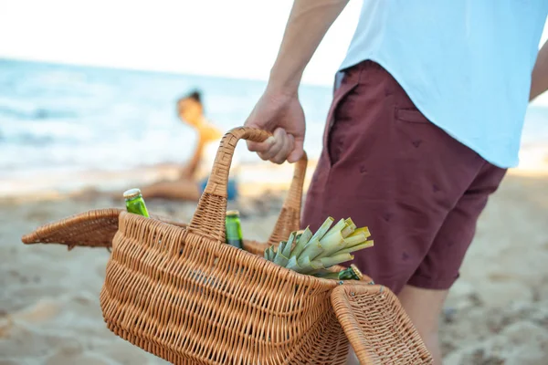 Частковий вид міжрасової пари, що має пікнік на піщаному пляжі — стокове фото
