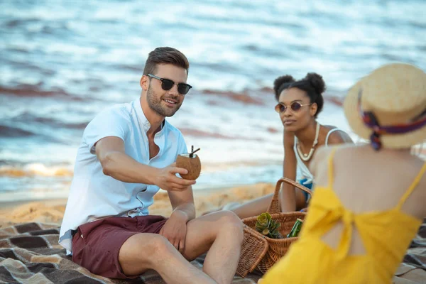 Selective focus of group of friends resting on sandy beach together — Stock Photo