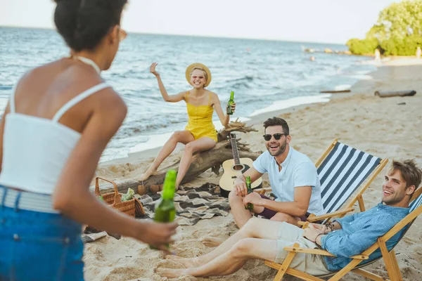 Focus selettivo di giovani amici multiculturali che trascorrono del tempo insieme sulla spiaggia di sabbia — Foto stock