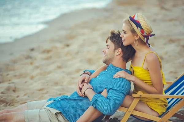 Vista lateral de pareja joven descansando en la playa en el día de verano - foto de stock