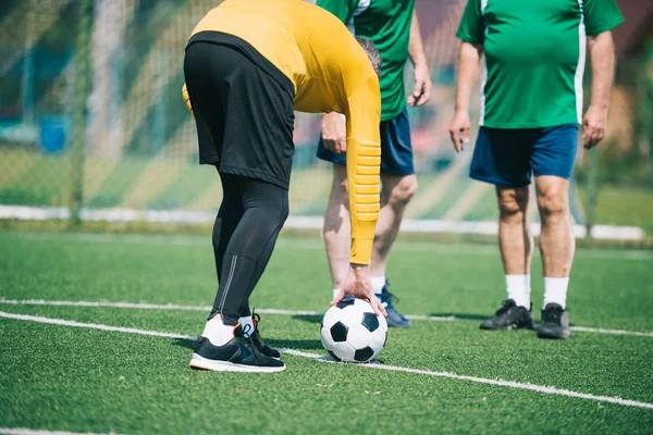 Teilansicht alter Männer, die gemeinsam auf dem Feld Fußball spielen — Stockfoto