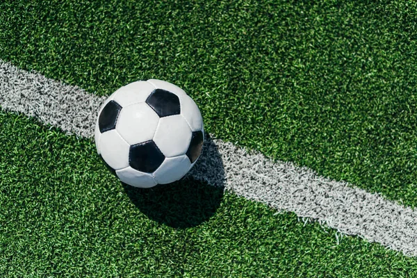 Vista superior de la pelota de fútbol sobre hierba verde con línea blanca - foto de stock