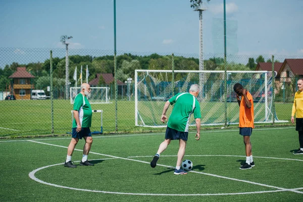 Amis âgés multiculturels jouer au football ensemble — Photo de stock