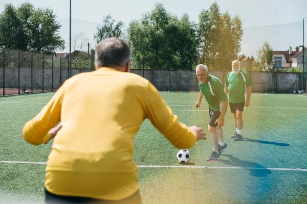 Vista posterior del portero y los hombres mayores en el campo de fútbol - foto de stock