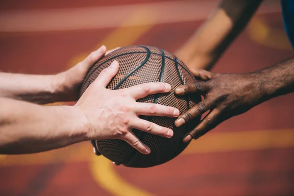 Partial view of man giving basketball ball to old african american friend — Stock Photo