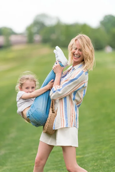 Beautiful happy mother and little daughter having fun together in park — Stock Photo