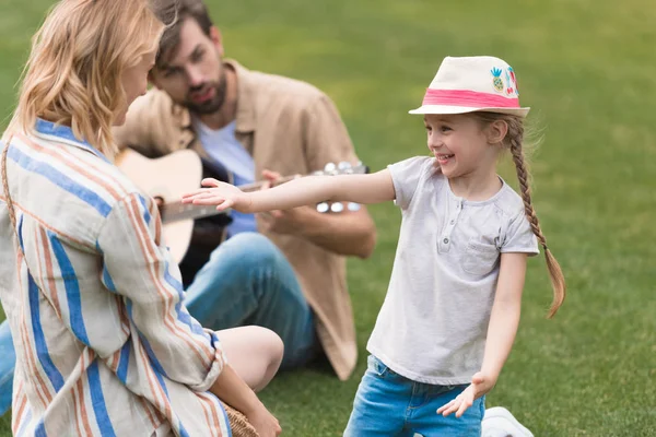 Glückliche Familie mit einem Kind, das Zeit miteinander im Park verbringt — Stockfoto