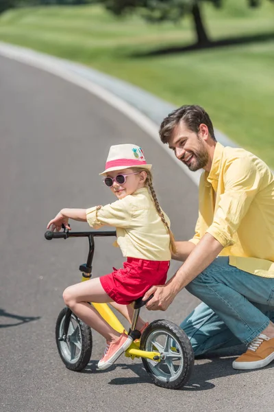 Glücklicher Vater lehrt entzückende kleine Tochter Fahrrad fahren im Park — Stockfoto