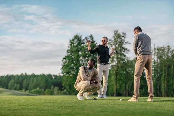 Groupe de jeunes amis multiculturels élégants passer du temps ensemble tout en jouant au golf — Photo de stock