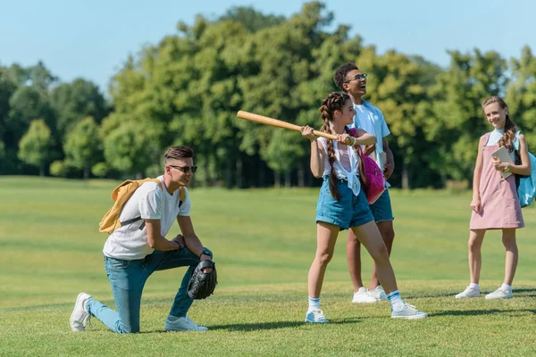 Grupo multiétnico de adolescentes jugando béisbol juntos en el parque - foto de stock
