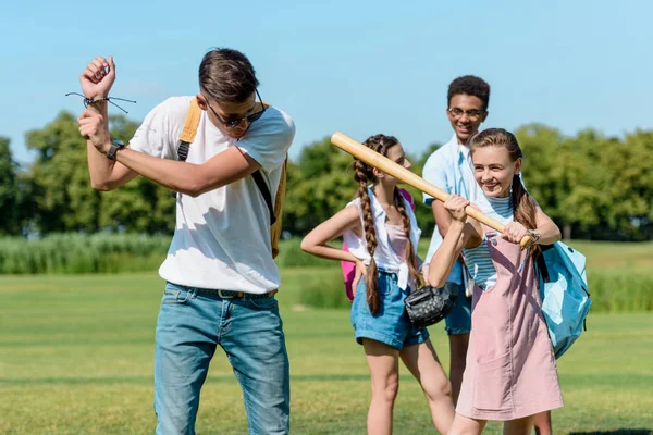 Adolescentes sonrientes divertirse y jugar béisbol en el parque - foto de stock