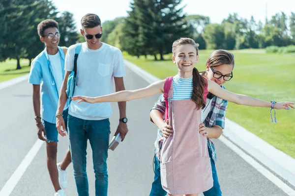 Heureux amis adolescents multiethniques s'amuser tout en marchant ensemble dans le parc — Photo de stock
