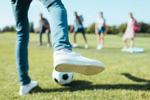 Schnappschuss von Junge, der mit Freunden im Park Fußball spielt — Stockfoto