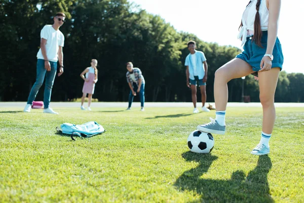 Amigos multiétnicos adolescentes jogando com bola de futebol no parque — Fotografia de Stock