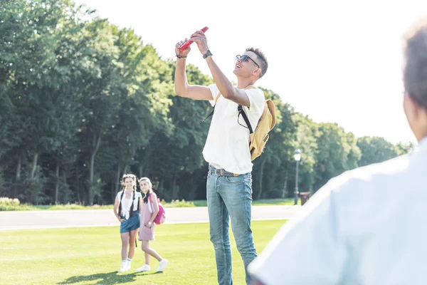 Foco seletivo de amigos adolescentes brincando com disco voador no parque — Fotografia de Stock