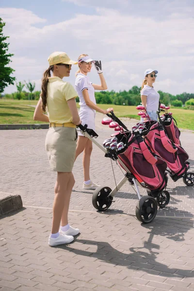 Female golfers with golf equipment walking at golf course — Stock Photo