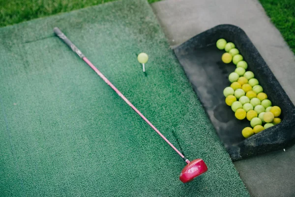 Vue de dessus du club de golf arrangé et des balles sur la pelouse verte — Photo de stock