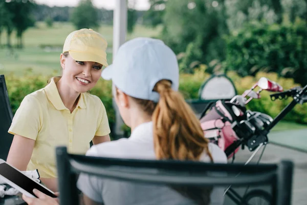 Бізнес-партнери з планшетом обговорюють роботу після гри в гольф на полі для гольфу — стокове фото