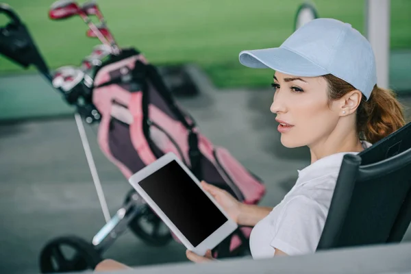 Вид збоку рутинного жіночого гравця в гольф з планшетом в руках на поле для гольфу — стокове фото