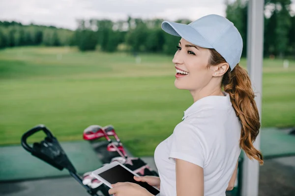 Vue latérale du joueur de golf féminin joyeux avec tablette dans les mains au terrain de golf — Photo de stock