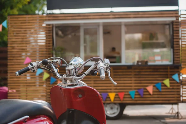 Vue rapprochée du scooter rouge et du camion alimentaire derrière — Photo de stock