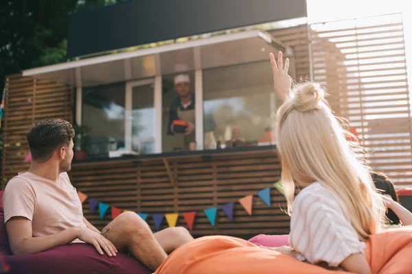 Girl showing three fingers to chef in food truck — Stock Photo