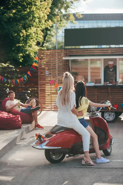 Rückansicht von Mädchen auf rotem Roller in der Nähe von Food-Truck — Stockfoto