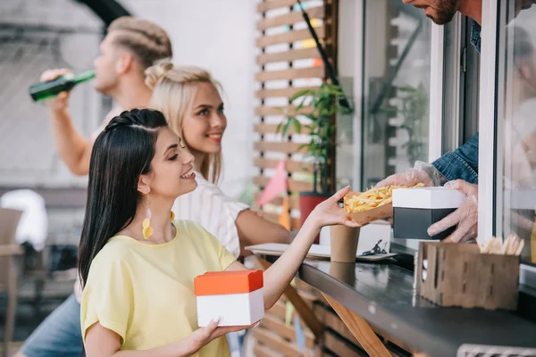 Geschnittenes Bild von Koch, der Pommes frites an Kunden aus Foodtruck verschenkt — Stockfoto