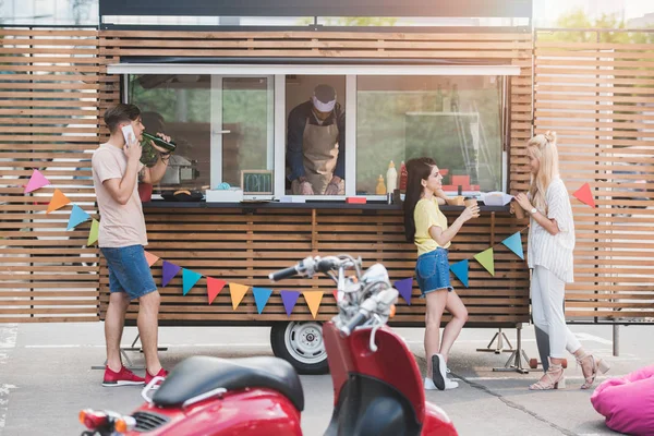 Clientes pasar tiempo y hablar en camión de comida - foto de stock