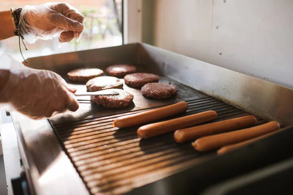 Imagen recortada de chef preparando carne para hamburguesas en camión de comida - foto de stock