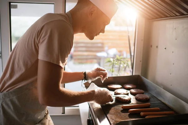 Vista laterale dello chef che prepara carne per hamburger nel camion alimentare — Foto stock