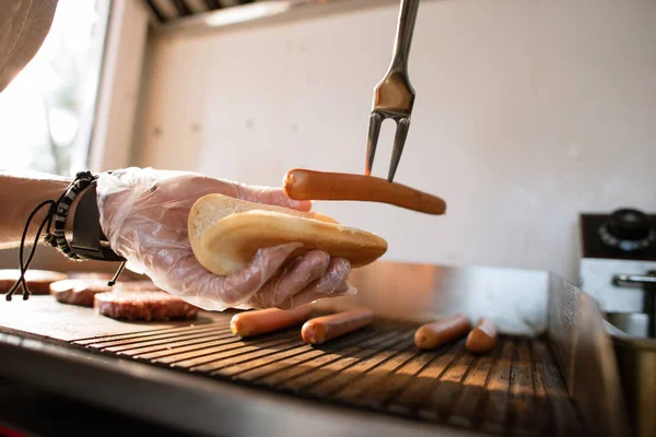 Imagem cortada de chef preparando cão de porco no caminhão de alimentos e adicionando salsicha — Fotografia de Stock