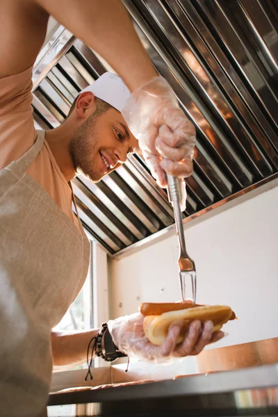 Visão de baixo ângulo do chef preparando hod dog no caminhão de alimentos — Fotografia de Stock