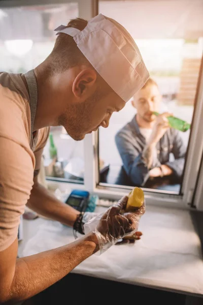 Chef preparing hod dog in food truck — Stock Photo