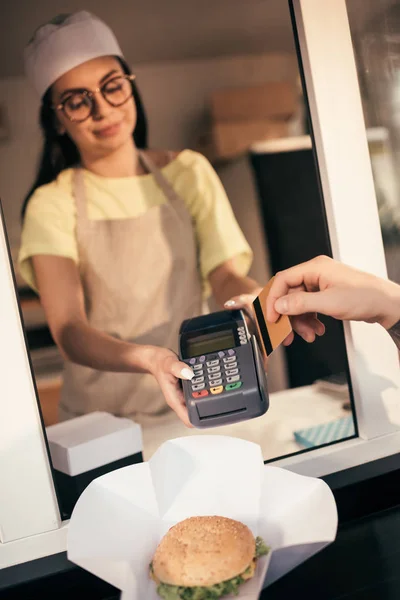 Imagem cortada do cliente pagando com cartão de crédito para alimentos no caminhão de alimentos — Fotografia de Stock