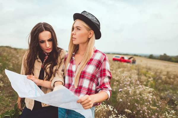 Confundido jóvenes novias con mapa de pie en el campo y tratando de navegar - foto de stock