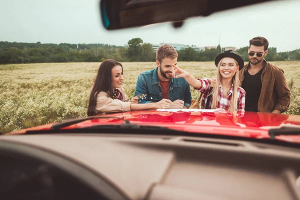 Vista de carro em grupo de viajantes que planejam viagem no campo de flores — Fotografia de Stock