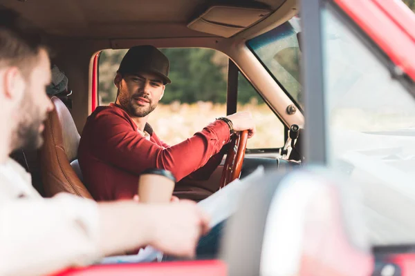 Guapos jóvenes teniendo coche viaje y charlando - foto de stock