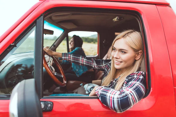 Side view of happy young girlfriends having car trip and riding through fields — Stock Photo