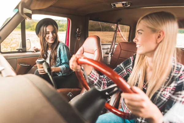 Felizes jovens namoradas tendo viagem de carro e conversando no carro — Fotografia de Stock