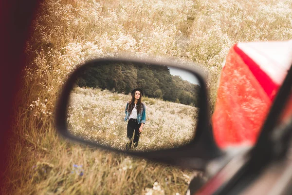 Miroir côté automatique reflet de belle jeune femme marchant dans le champ de fleurs seul — Photo de stock