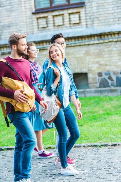 Groupe d'étudiants multiethniques avec sacs à dos marchant dans le parc — Photo de stock