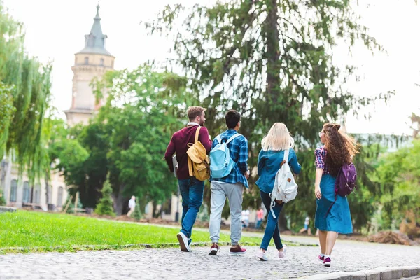 Back view of students with backpacks walking on street — Stock Photo