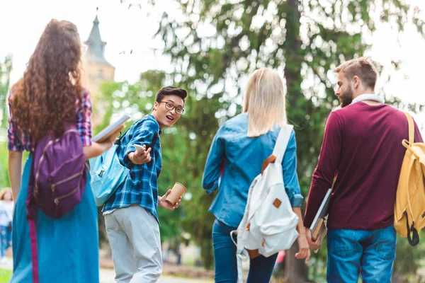 Concentration sélective des étudiants multiculturels avec des sacs à dos marchant dans la rue — Photo de stock