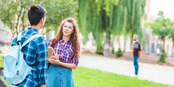 Visão parcial de estudantes multirraciais conversando no parque — Fotografia de Stock