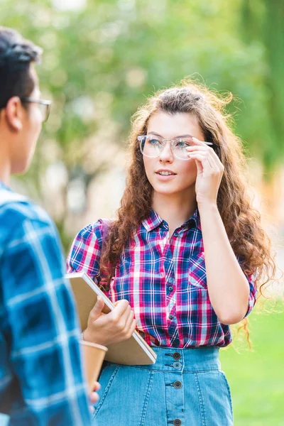 Partial view of multiracial students having conversation in park — Stock Photo