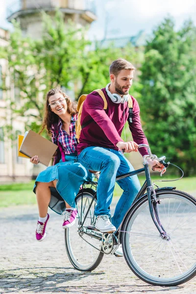 Jovens estudantes andando de bicicleta juntos no parque — Fotografia de Stock